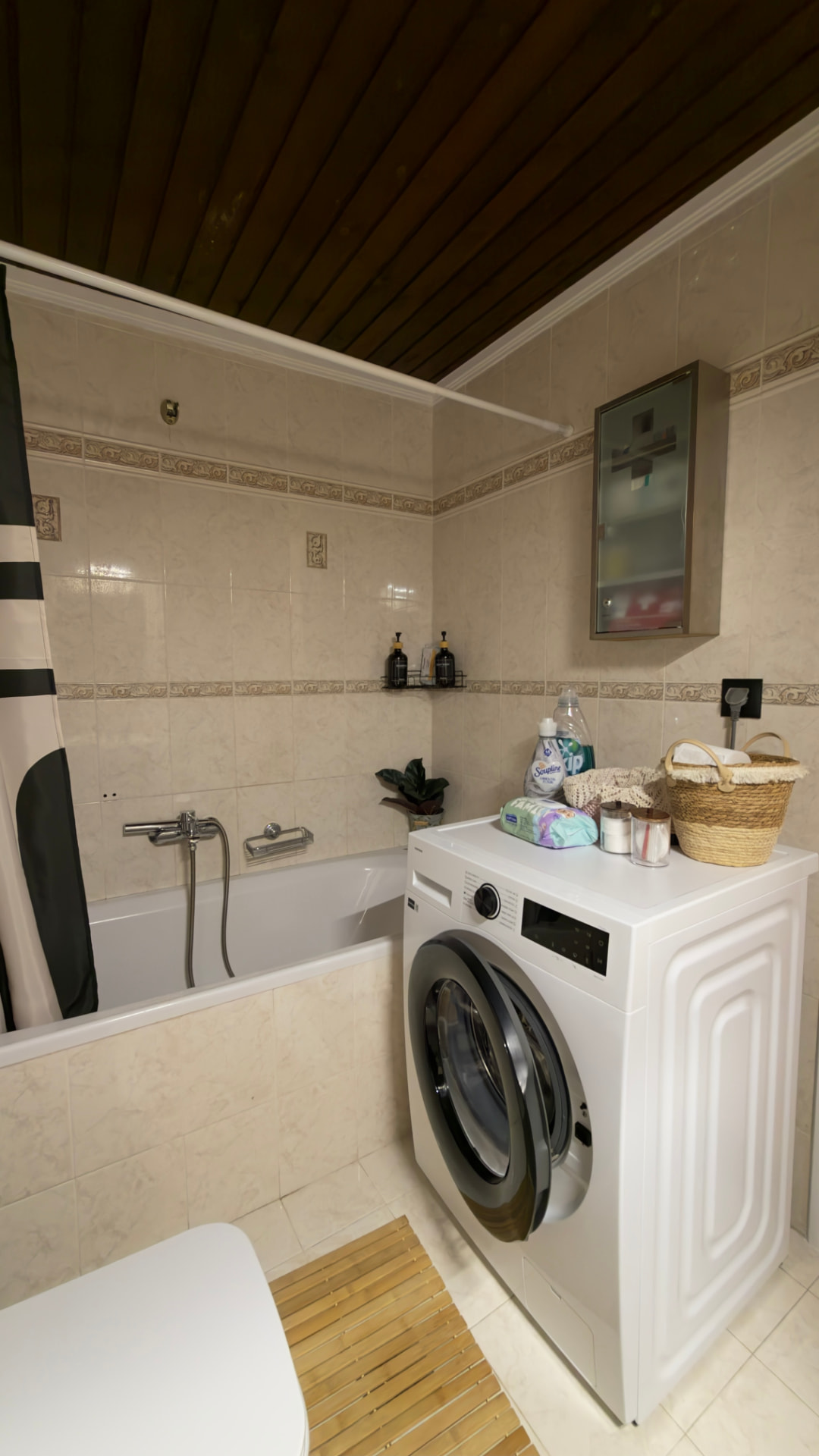 Bathroom with bathtub, washing machine and bath products