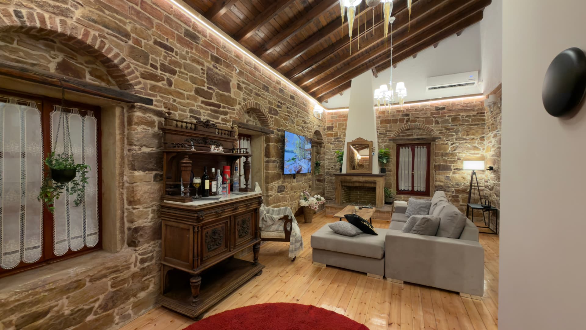 Living room with fireplace, wooden sideboard and stone walls