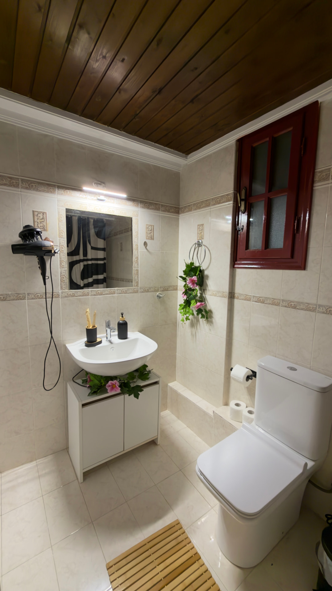 Bathroom with washbasin, mirror, hair dryer and timber ceiling